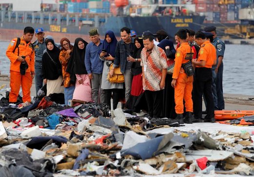 خانواده‌های مسافران هواپیمای سقوط کرده اندونزی در بندر ایستاده‌اند و به لوازم قربانیان نگاه می‌کنند