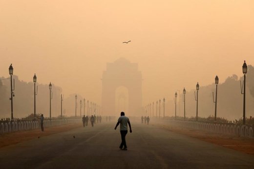 یک مرد در مقابل دروازه هند یا ایندیا گیت راه می‌رود