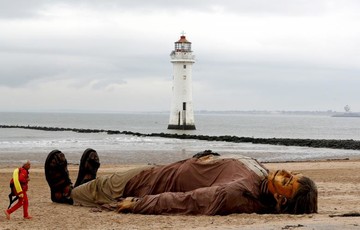 مامور نجات غریق مقابل یک عروسک در سواحل New Brighton بریتانیا