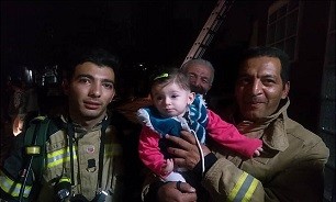 نجات دختر بچه‌ ۸ ماهه از میان دود/ عکس