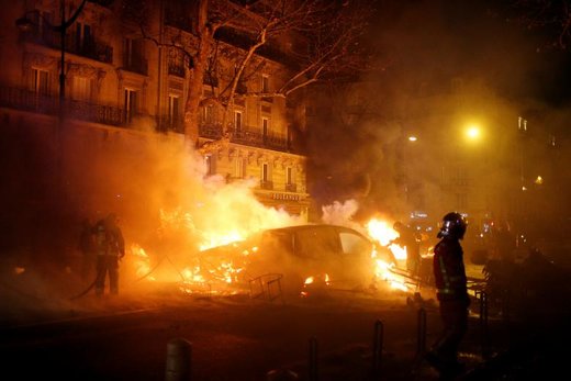 آتش نشان ها در حال خاموش کردن آتش سوزی های  ایجاد شده به هنگام درگیری جلیقه زردها با پلیس در شهر پاریس