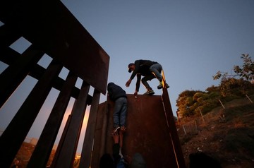 تلاش یک مهاجر هندوراسی برای عبور از مرز آمریکا در شهر تیخوانا مکزیک