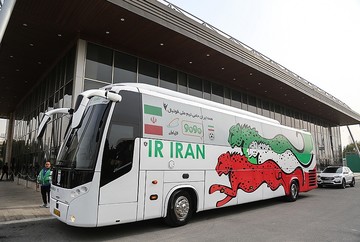 چند جوان برای روکم‌کنی شیشه اتوبوس‌های بی‌آرتی را پایین می‌آورند