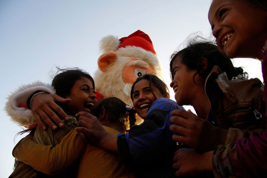 بابانوئل در شهر نجف عراق کودکان را سرگرم کرده و هدایایی میان آنها توزیع می کند