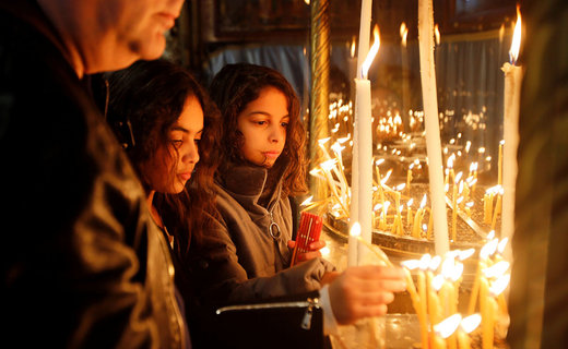دختران در کلیسایی در  بیت لحم شمع روشن می‌کنند