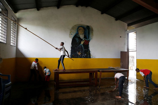 پسران به تمیز کردن یک کلیسا برای آماده سازی جشن کریسمس در شهر کینشاسا کنگو کمک می‌کنند