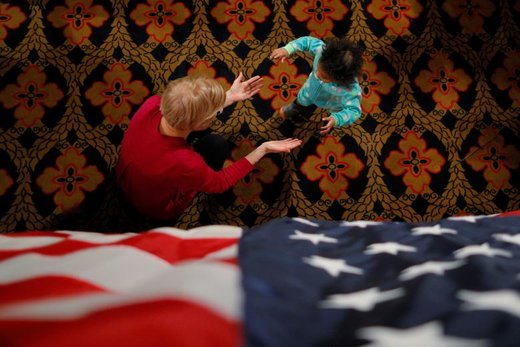 الیزابت وارن، عضو مجلس سنای ایالات متحده آمریکا، یک دختر بچه را در رویدادی در شهر سو سیتی ایالت آیووا در آغوش می‌گیرد