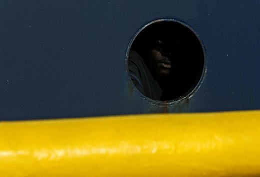یک مهاجر از دریجه عرشه کشتی جستجو و نجات مهاجران پروفسور آلبرچت پنک به بیرون نگاه می کند. این کشتی توسط یک سازمان  دریایی آلمان در سواحل مالت فعالیت می کند