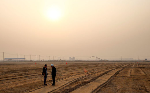 کارکنان در 10 اکتبر 2016 در محل ساخت فرودگاه بین‌المللی داشینگ پکن ایستاده اند