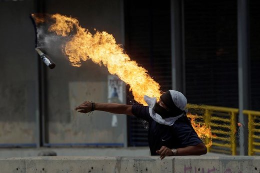 یک تظاهر کننده هندوراسی در تظاهرات علیه رئیس‌جمهور کشورش بمب دست سازی را به سوی پلیس پرتاپ می کند 