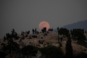 ماه کامل به بالای تپه Areios Pagos در محوطه باستانی آکروپولیس شهر آتن یونان رسیده است
