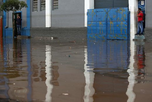 مردم منتظر پایین آمدن سطح آب پس از بارش شدید باران و وقوع سیلاب در شهر سائو پائولو برزیل هستند