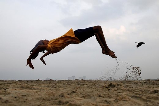 یک پسربچه در حال تمرین معلق زدن و ورزش کردن در کوچی هند