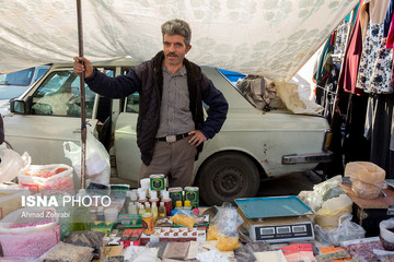 آقای باقری، متولد ۱۳۵۱، از ۶ سال قبل در روز بازار قم عطاری دارد، او از کودکی قالی‌باف بوده که به دلیل رکود شدید در صنعت فرش و قالی دست‌باف بیکار شد و پس از مدتی بیکاری تصمیم به دستفروشی در روزبازار کرد