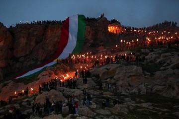 مردم کردستان عراق در  مراسم جشن باستانی نوروز در شهر عقره، مشعلی را تا بالای کوه حمل می‌کنند