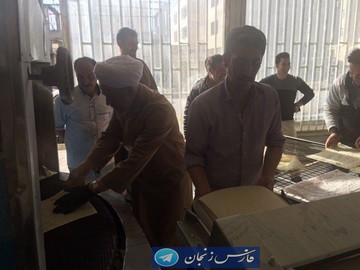 عکس یک امام جمعه در حال پخت نان برای کمک به سیل‌زدگان