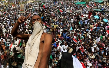 یک معترض سودانی در شهر خارطوم پشت کامیون ارتش سوار شده و تاکید دارد که عمر البشیر، رئیس‌جمهور برکنار شده این کشور، باید جایگرین شورای نظامی ارتش شود