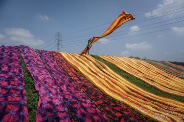 یک کارگر در طی فرآیند خشک کردن Sukoharjo در نزدیکی استان جاوه مرکزی اندونزی، پارچه‌ای را پرتاب می‌کند