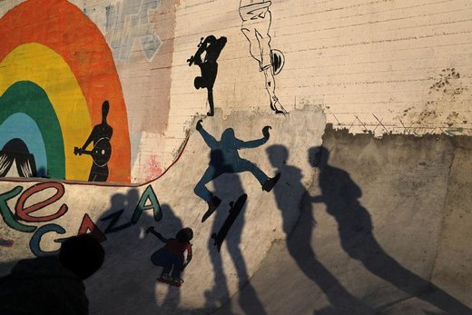 اعضای تیم اسکیت غزه که در نواحی ساحلی تمرین می‌کنند، سایه‌های خود را بر روی دیوار انداخته‌اند