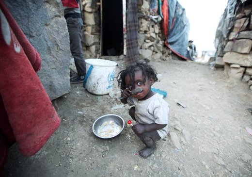 یک کودک آواره  که از جنگ در استان تعز یمن فرار کرده، در حومه شهر صنعا برنج می‌خورد