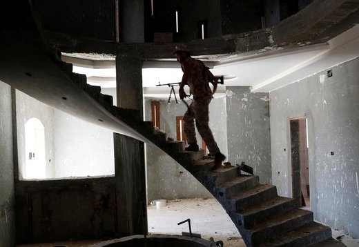 یکی از جنگجویان وفادار به دولت لیبی در داخل ساختمانی در حومه طرابلس، راه می رود