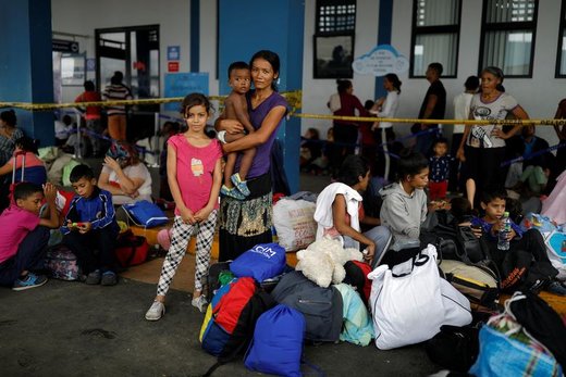 زن مهاجر ونزوئلایی قبل از ادامه مهاجرت در شهر تومبس پرو با فرزندانش عکس می‌گیرد