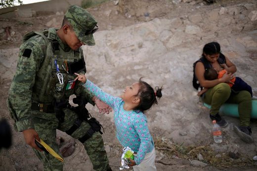 یکی از اعضای گارد ملی مکزیک با یک دختر هندوراسی در شهر سیوداد خوارس بازی می‌کند که به همراه مادر و خواهرش به صورت غیرقانونی در حال رفتن به شهر ال‌پاسو ایالت تگزاس هستند