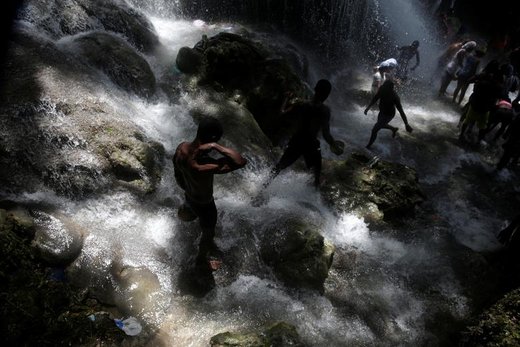 مردم هائیتی در آبشار حمام می‌کنند