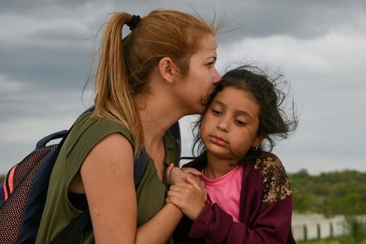 یک مادر ونزوئلایی با دختر 7 ساله‌اش پس از اینکه به صورت غیر قانونی از ریو گرانده واقع در نزدیکی شهر میشن ایالت تگزاس آمریکا عبور کردند، به سوی مراکز قانونی می‌روند تا درخواست پناهندگی کنند