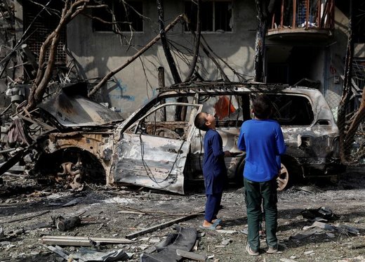پسران افغانستانی محل وقوع حمله انتحاری در شهر کابل را نگاه می‌کنند