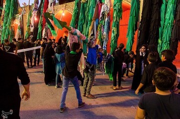 علم‌ها را با جامه، پارچه و دستمال‌های رنگارنگی که مردم نذر کرده اند، می‌پوشانند و با نوحه خوانی و عزاداری، علم‌ها را دور حسینیه می‌گردانند