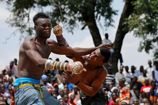 یک بوکسور Dambe در حین مسابقه در Dei-Dei در آبوجا نیجریه حریف خود را با مشت می زند