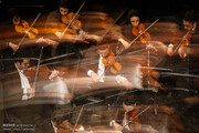 سوری‌های خانه‌نشین از تلویزیون اجرای ارکستر «اورفئوس» را تماشا می‌کنند
