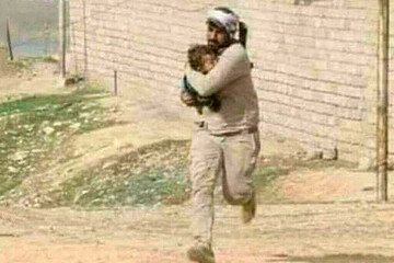 تصویری از شهید ابوجعفر العلیاوی در حال کمک به مردم برای فرار از دست داعش