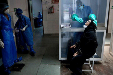 عکس | تست کرونا از پشت محفظه شیشه‌ای