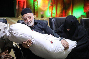 عکس | تصویری غم انگیز از پدر و مادری که فرزند شهیدشان را در آغوش کشیدند