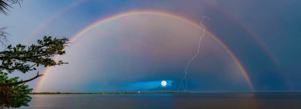 عکس | تصویری شگفت انگیز و نادر از پیدایش همزمان رنگین کمان و صاعقه در آسمان