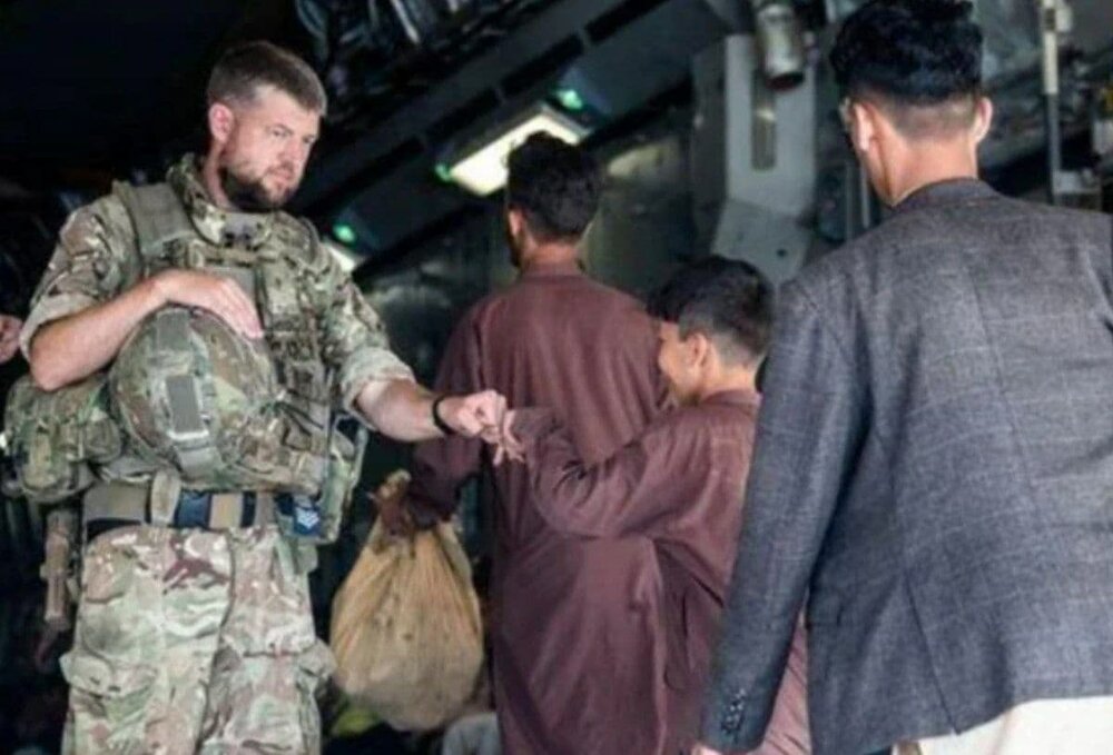 مهاجران افغانستانی در حال سوار شدن به هواپیمای نظامی بریتانیا در فرودگاه حامد کرزای کابل/