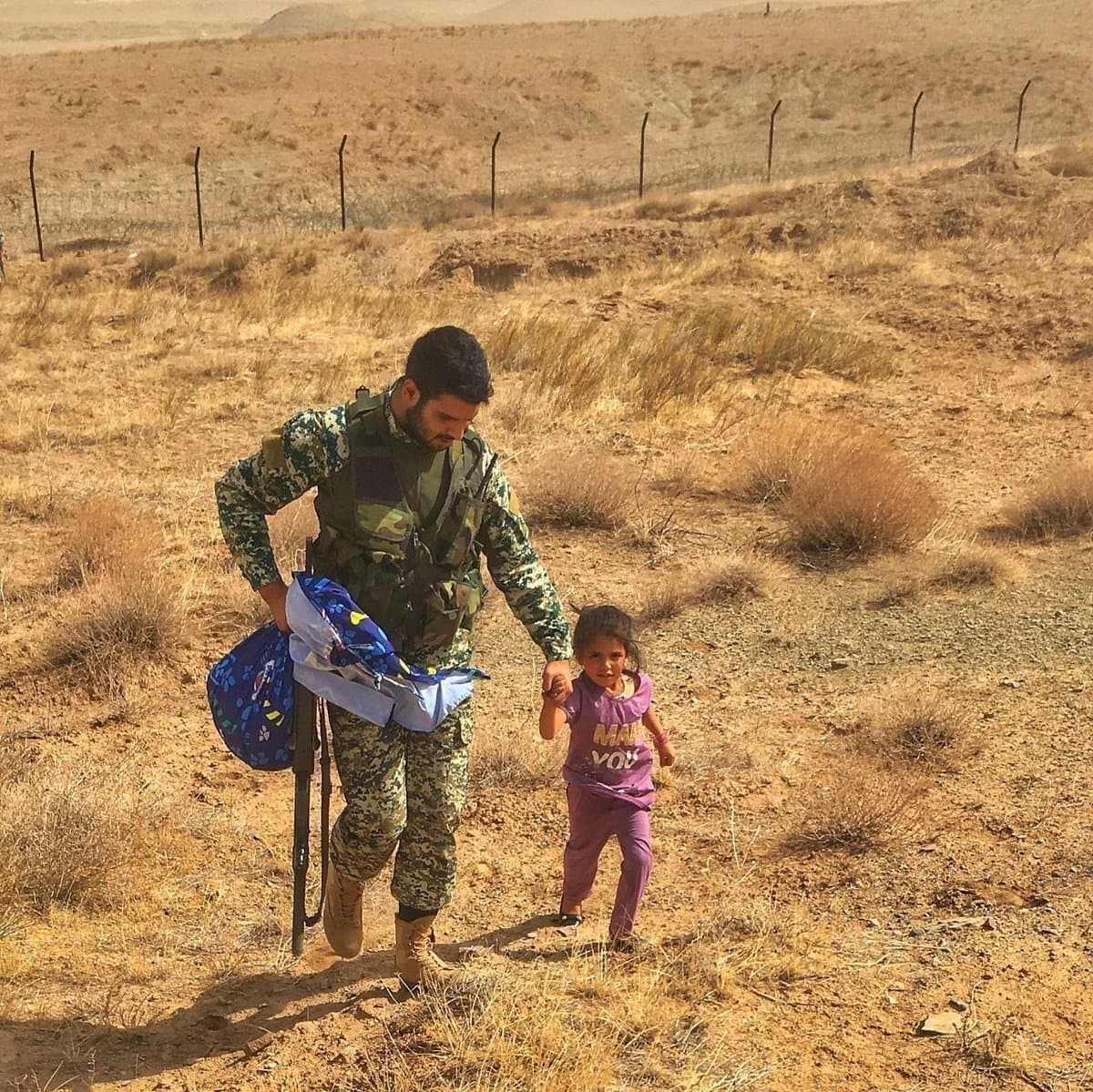 عکس| تصویری تلخ از پناه آوردن کودک افغان به تکاور ایرانی
