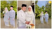 ببینید | برگزاری عجیب و خبرساز جشن عروسی وسط سیلاب توسط زوج مالزیایی