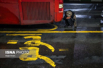 عکس| تصویری تلخ از واقعیت دیده نشده تهران/ گرم شدن با اگزوز اتوبوس در شب‌های سرد زمستانی