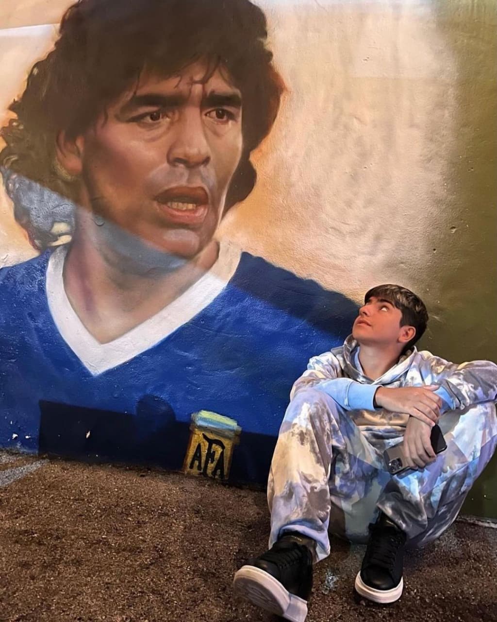 نگاه خاص پسر آگوئرو به نقاشی مارادونا/عکس
