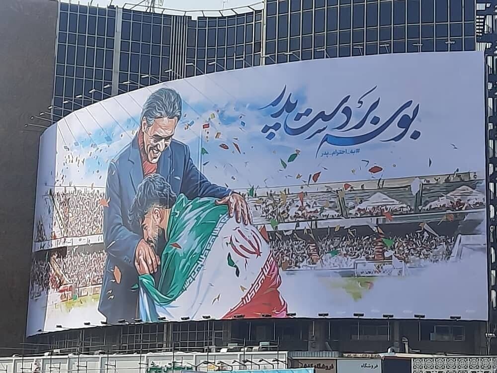 عکس | بوسه امیر عابدزاده به دستان پدر، روی دیوارنگاره میدان ولیعصر