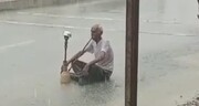 ببینید | تصویری عجیب از قلیان کشیدن یک پیرمردی وسط سیل و باران در بوشهر!