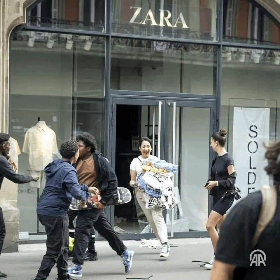 عکس | خوشحالی یک دختر در اعتراضات فرانسه پس از سرقت از فروشگاه برند زارا