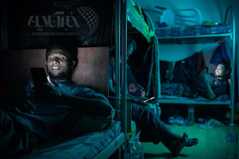 عکس | لبخندهای پرمعنای کارگر بنگلادشی در حال گفتگوی تصویری با خانوادهاش