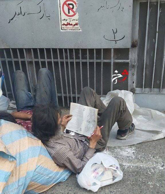 عکس | فریمی تلخ از یک کارتنخواب در حال حل کردن جدول