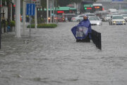 ببینید | تصاویر تلخ از تقلا کردن یک زن وسط سیل چین و چنگ زدن به یک چتر برای نجات!
