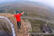 ببینید | حرکات نمایشی و ترسناک مرد رومانیایی روی لبه دودکش صنعتی ٢٥٦ متری