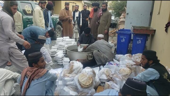 طالبان در حال پخش پول و غذا بین مهاجران افغان/عکس